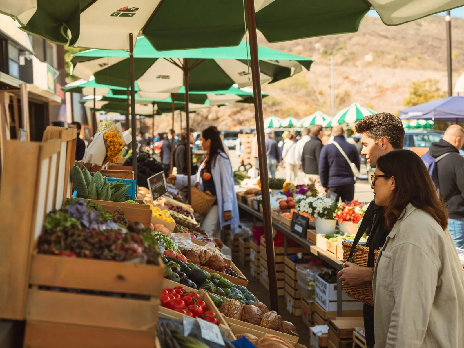 A busy farmers market with booths of fresh produce