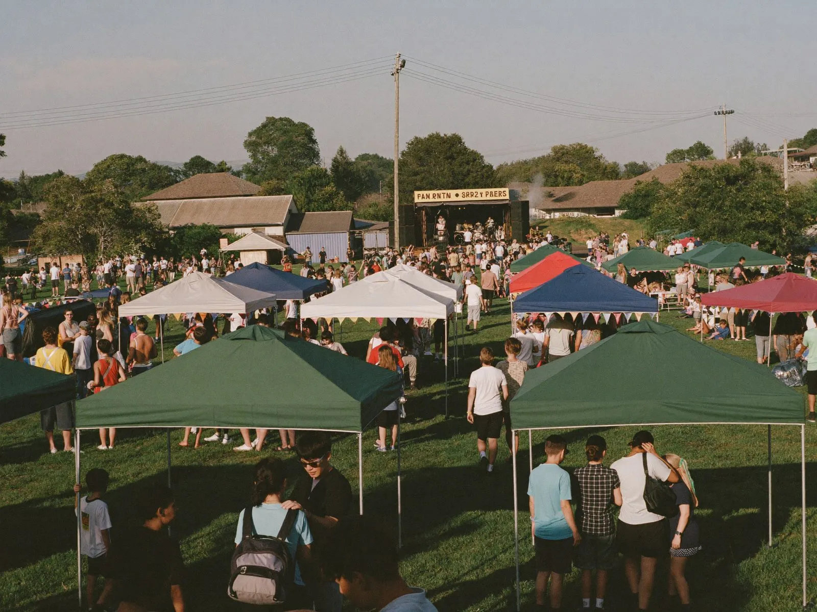 An outdoor festival with market booths and a stage