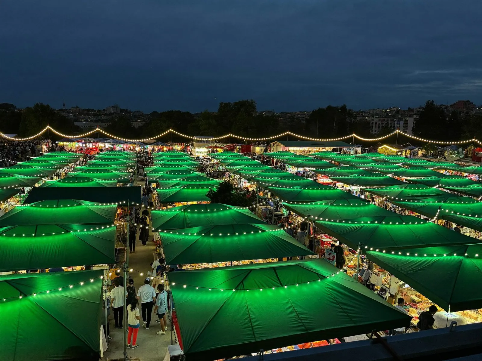 A night market glowing under string lights with food booths